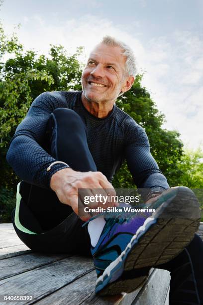 portrait of an active content senior man exercising in a park - tied up ストックフォトと画像