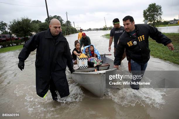 The Tellez family is evacuated from their home after severe flooding following Hurricane Harvey in north Houston August 29, 2017 in Houston, Texas....