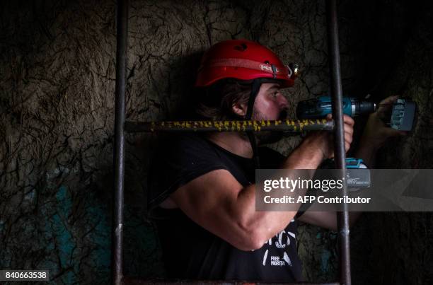 Iulian Angheluta, the founder of an NGO that tries to bring electricity to remote villages, prepares to install a solar panel on a house, July 25 in...