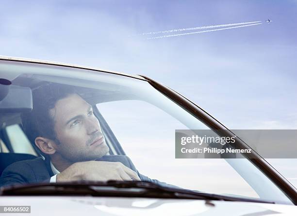 man in car looking at jetplane in sky - philipp nemenz foto e immagini stock