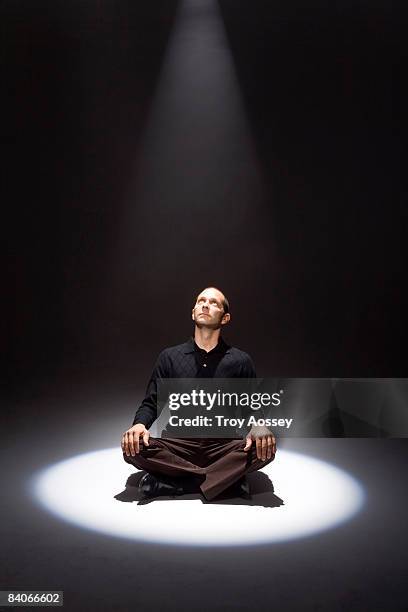 man bathed in shaft of light looking up - spotlight person stock pictures, royalty-free photos & images