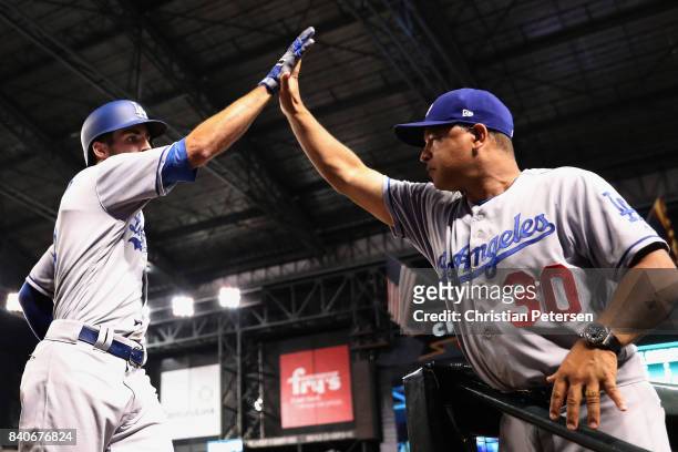 Chris Taylor of the Los Angeles Dodgers high fives manager Dave Roberts after hititng a two run home run against the Arizona Diamondbacks during the...