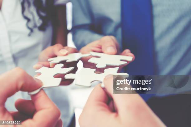 gruppe von geschäftsleuten, die halten ein jigsaw puzzle-teile. - business relationships stock-fotos und bilder