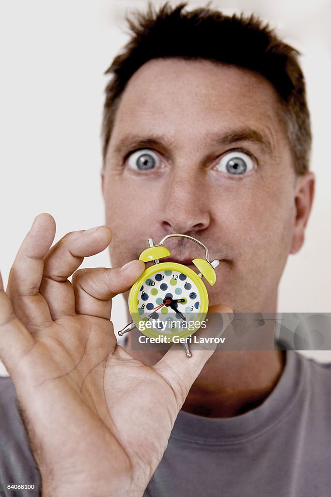 Man holding small clock