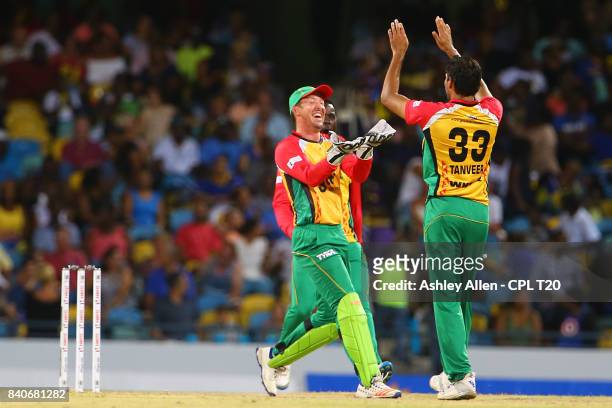 In this handout image provided by CPL T20, Luke Ronchi and Sohail Tanvir of the Guyana Amazon Warriors celebrate the wicket Kane Williamson during...