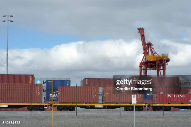 Shipping containers sit stacked on well cars and near a gantry crane at the Port of Fremantle, Western Australia, Australia, on Saturday, Aug. 5,...