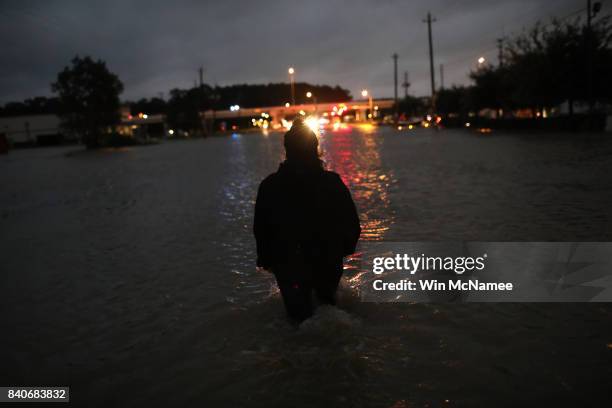 Houston resident walks through waist deep water while evacuating her home after severe flooding following Hurricane Harvey in north Houston August...