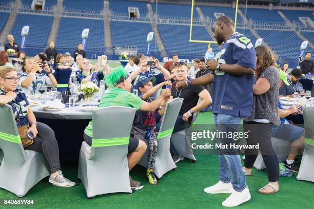 Seattle Seahawks star Cliff Avril greets hundreds of fans and Seattle business owners during American Express "Dinner on the 50" at CenturyLink Field...