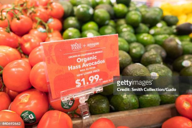 Signage on a display of avocados at the Whole Foods Market store in Lafayette, California reading "Whole Foods Market and Amazon, New Lower Price,...