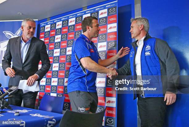 Brad Scott, coach of the Kangaroos is congratulated by Kangaroos CEO & Managing Director Carl Dilena and Kangaroos Chairman Ben Buckley as he leaves...