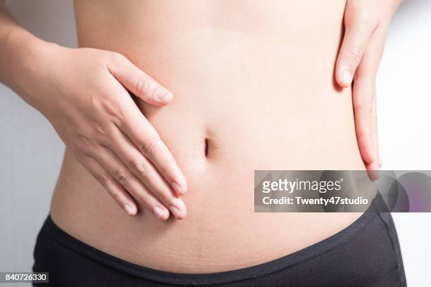pregnancy or diet concept, female hands protecting the stomach on white background. - abdomen stock pictures, royalty-free photos & images