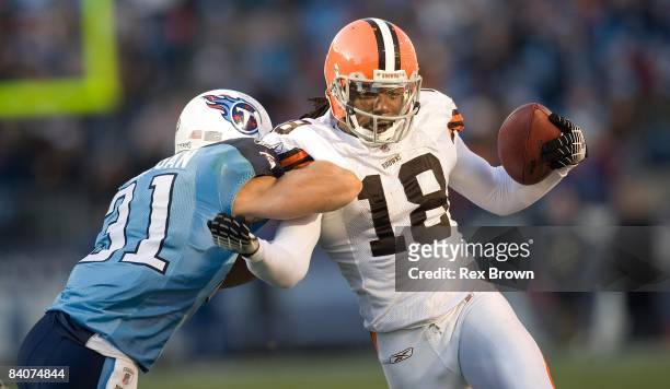 Donte Stallworth of the Cleveland Browns it hit by Cortland Finnegan of the Tennessee Titans as he carries for a first down against the Tennessee...