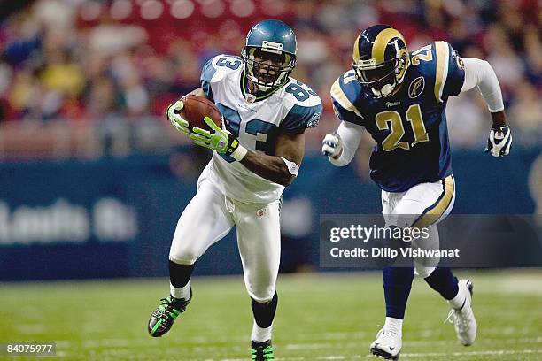 Deion Branch of the Seattle Seahawks carries the ball against Oshiomogho Atogwe of the St. Louis Rams at the Edward Jones Dome on December 14, 2008...