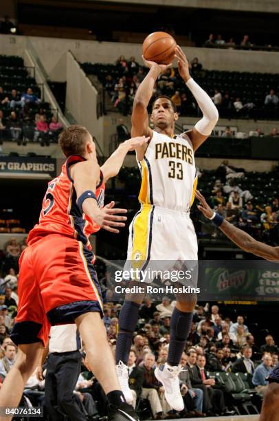 Danny Granger of the Indiana Pacers shoots over Andris Biedrins of the Golden State Warriors at Conseco Fieldhouse on December 18, 2008 in...