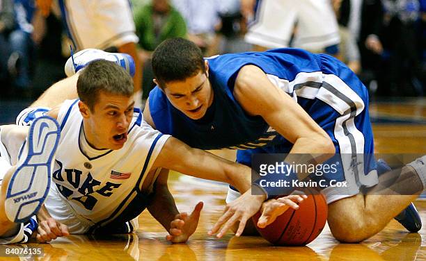 Jon Scheyer of the Duke Blue Devils dives for a loose ball against Matt Dickey of the North Carolina Asheville Bulldogs during the game on December...