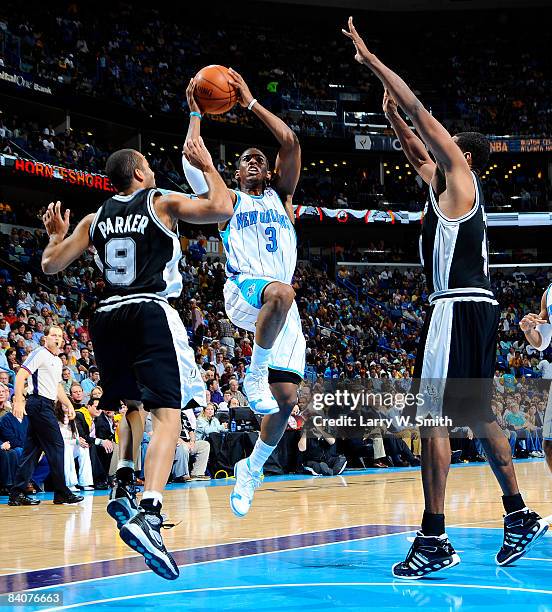 Chris Paul of the New Orleans Hornets shoots between Tony Parker and Kurt Thomas of the San Antonio Spurs at the New Orleans Arena December 17, 2008...