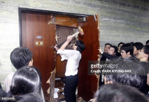 South Korean opposition party member uses a hammer to tear down the door of a parliamentary committee room barricaded by ruling party legislators in...