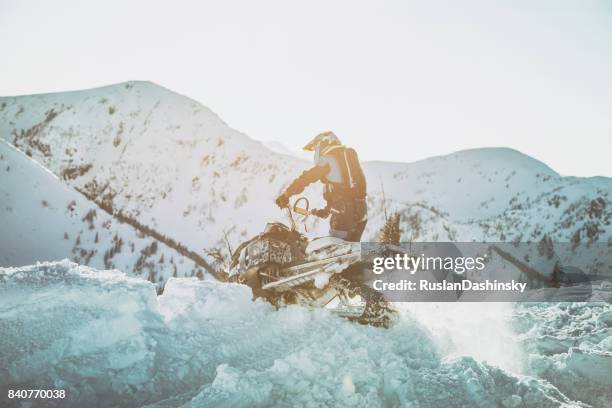 snowmobiling through a snow drift. - snowmobile stock pictures, royalty-free photos & images
