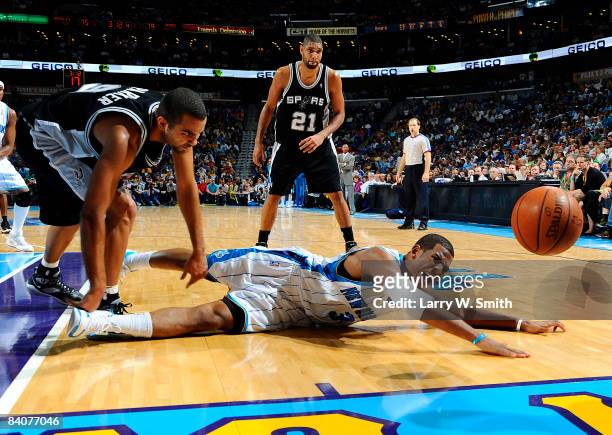 Chris Paul of the New Orleans Hornets reaches for a loose ball against Tony Parker and Tim Duncan of the San Antonio Spurs at the New Orleans Arena...