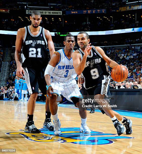 Tony Parker of the San Antonio Spurs drives around Tim Duncan of the Spurs and Chris Paul of the New Orleans Hornets at the New Orleans Arena...