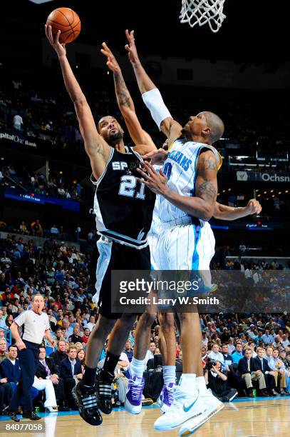 Tim Duncan of the San Antonio Spurs shoots against David West and Tyson Chandler of the New Orleans Hornets at the New Orleans Arena December 17,...