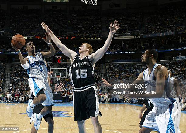 Chris Paul of the New Orleans Hornets shoots over Matt Bonner of the San Antonio Spurs as he is guarded by Tyson Chandler of the New Orleans Hornets...