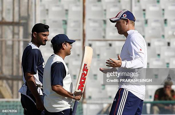 Indian cricketer Harbhajan Singh watches as teammate Sachin Tendulkar talks with England cricketer Andrew Flintoff during a training session at PCA...