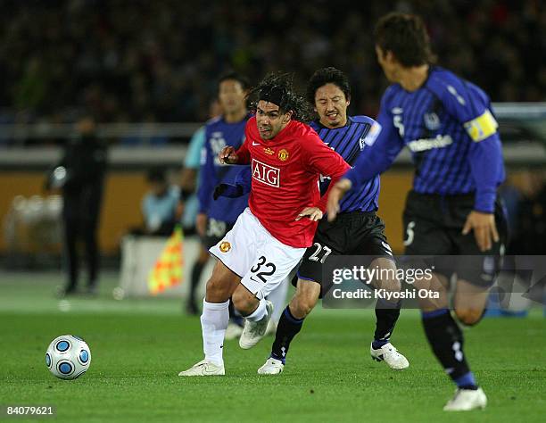 Carlos Tevez of Manchester United and Hideo Hashimoto of Gamba Osaka compete for the ball during the FIFA Club World Cup semi final match between...