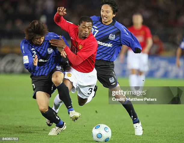 Patrice Evra of Manchester United clashes with Sota Nakazawa and Hideo Hashimoto of Gamba Osaka during the FIFA World Club Cup Semi-Final match...