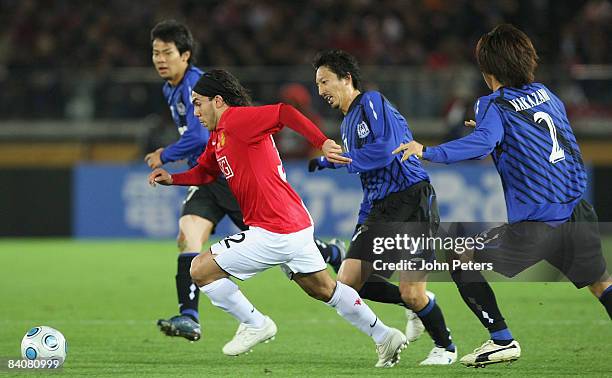 Carlos Tevez of Manchester United clashes with Hideo Hashimoto of Gamba Osaka during the FIFA World Club Cup Semi-Final match between Gamba Osaka and...