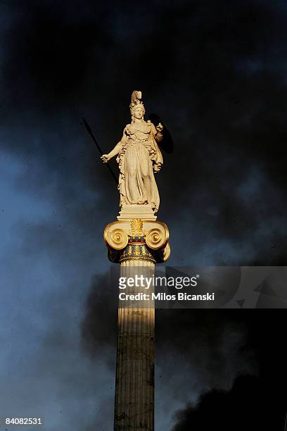 Cloud of black smoke rises around the statue of Athina, ancient patron goddess of Athens, during renewed clashes between a breakaway group of rioting...