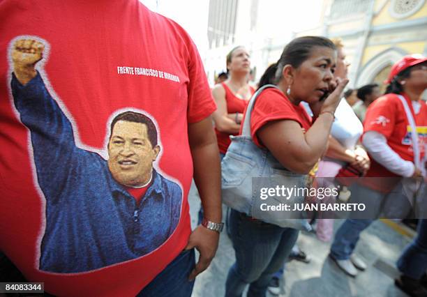 Supporter of Venezuelan President Chavez wears a t-shirt with his portrait during a rally in front of the parliament in Caracas on December 18, 2008....