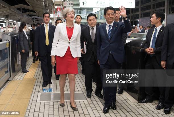 Britain's Prime Minister, Theresa May, waits with Japan's Prime Minister, Shinzo Abe, as they arrive at Kyoto Train Station to board a bullet train...