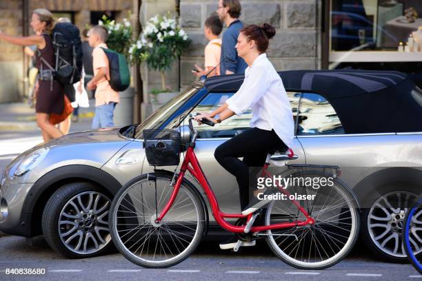 ung kvinna på cykel, trafik i bakgrunden - stureplan bildbanksfoton och bilder