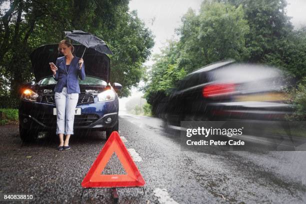 woman on side of road with broken down car in the rain - encalhado - fotografias e filmes do acervo