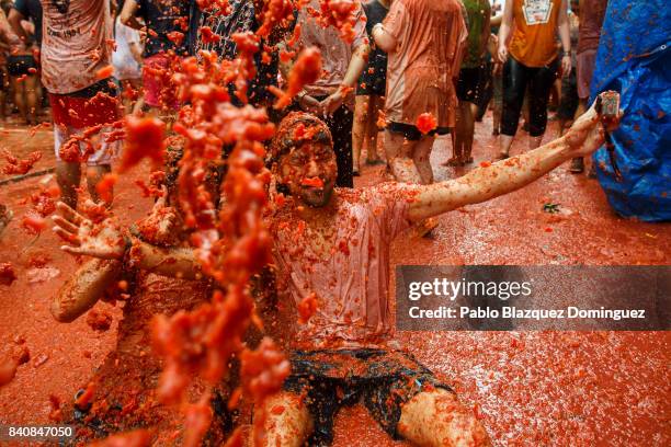 Revellers enjoy the atmosphere in tomato pulp while participating the annual Tomatina festival on August 30, 2017 in Bunol, Spain. An estimated...