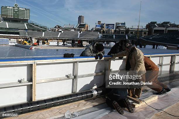 Workers construct an outdoor ice rink prior to a media briefing for the NHL Winter Classic at Wrigley Field on December 18, 2008 in Chicago,...