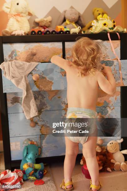 toddller looking in chest of drawers in bedroom - searching mess stock pictures, royalty-free photos & images