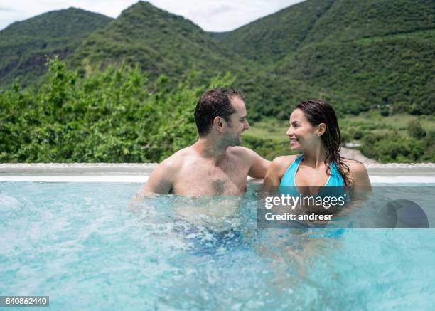 happy couple enjoying their summer holidays in the pool - happy holidays around the world stock pictures, royalty-free photos & images