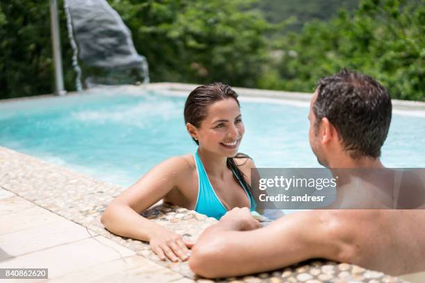 happy couple on holidays relaxing in the swimming pool - happy holidays around the world stock pictures, royalty-free photos & images