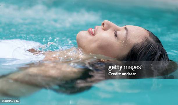 美麗的女人在游泳池中漂浮 - 女子水泳 個照片及圖片檔