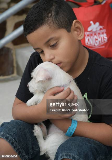 Joshua Lopez holds puppy Cali outside of College Park High School which was set up as a temporary shelter for Hurricane Harvey evacuaees in The...