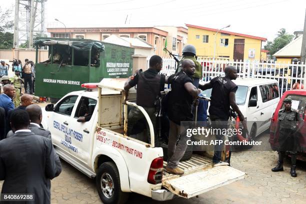 Nigerian ant-riot police officers escort a suspected kidnap kingpin to prison after he was arraigned at the Lagos State High Court on August 30,...