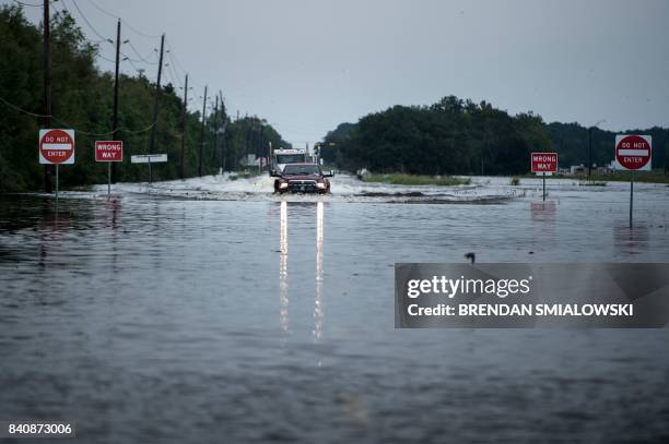 Trucks make their way through flood waters on a main road leading to the Arkema Inc. Chemical plant that was in crisis during the aftermath of...