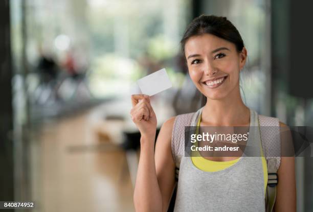 mujer feliz en el gimnasio con una tarjeta de fidelización - tarjeta de lealtad fotografías e imágenes de stock