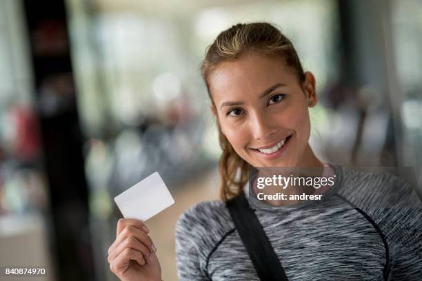 fit woman at the gym holding a loyalty card - loyalty program stock pictures, royalty-free photos & images