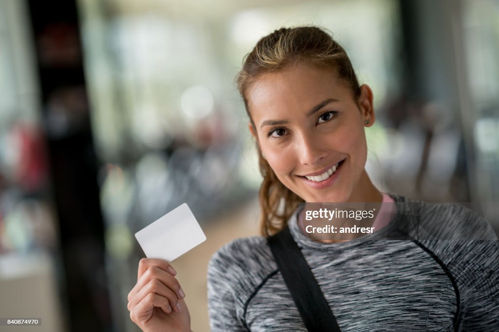Fit woman at the gym holding a loyalty card