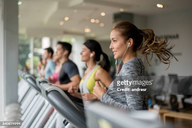 mooie vrouw uit te oefenen op de sportschool op een loopband - running on treadmill stockfoto's en -beelden