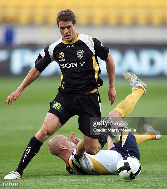 Tony Lochhead of the Phoenix is tackled by Andre Gumprecht of the Mariners during the round 16 A-League match between the Wellington Phoenix and the...