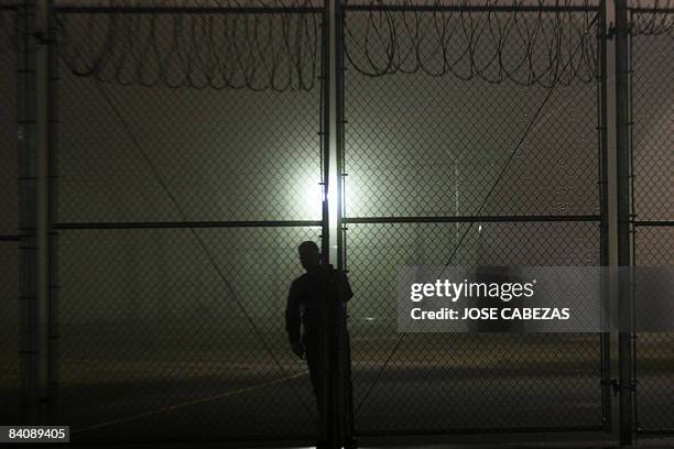 Security guard closes the gate at Willacy Detention facility in Raymondville, Texas on December 18, 2008 early morning. The Willacy facility is used...